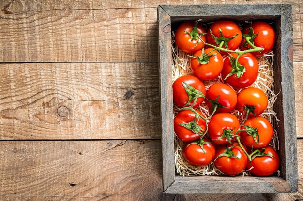 Tomates vermelhos em caixa de madeira