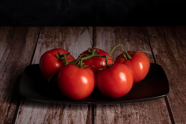 Tomates vermelhos estão sobre a mesa da cozinha