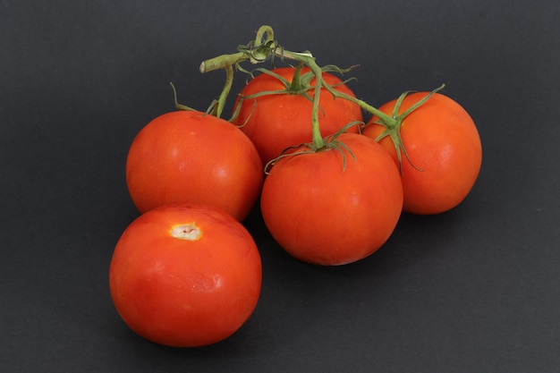 Tomates vermelhos frescos em um fundo preto