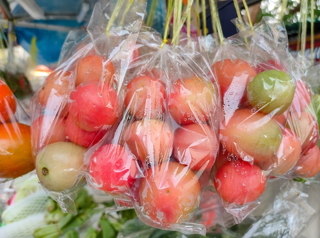 Tomates vermelhos frescos embalados em sacos plásticos prontos para venda no mercado de rua.