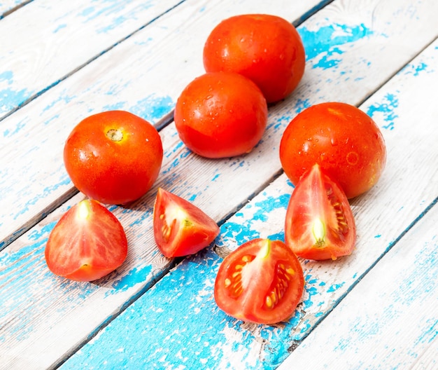 Tomates vermelhos na mesa de madeira velha azul