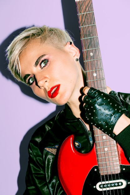 Foto tomboy girl mit elektrogitarre. rock-mode-stil