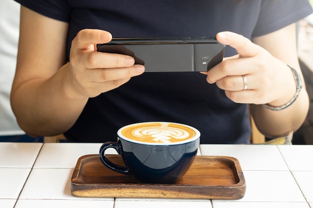 Tome café com leite de foto em um copo com telefone celular