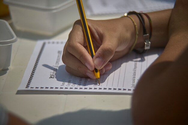 Foto tome notas con su bolígrafo escribiéndolas en una hoja de papel