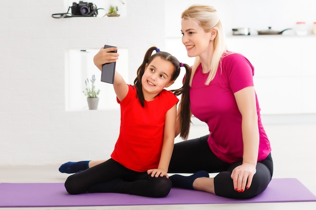 Tomemos una foto para la red social. Cerrar retrato de hermosa tierna tierna tierna deportiva linda madre e hija vistiendo ropa deportiva haciendo videollamadas a través de la conexión a Internet