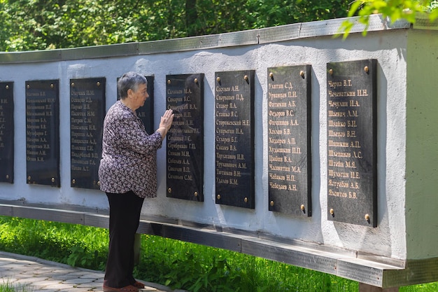 Tomsk Rusia mayo de 2022 Triste mujer mayor cerca del monumento en memoria de los estudiantes de TSU editorial