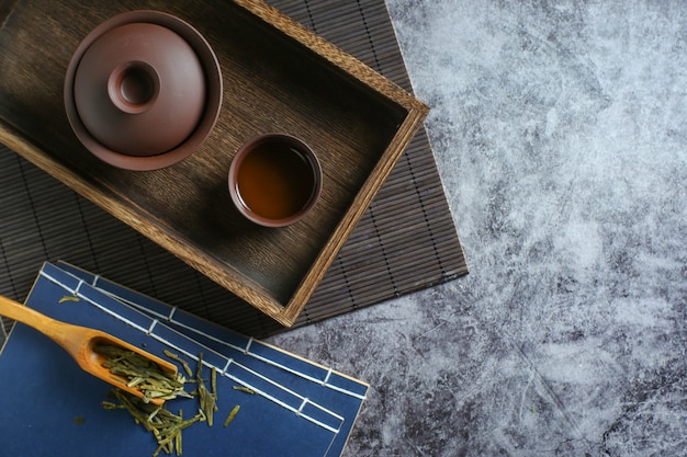 Ton-Teeset und Teebuch auf dunklem Zementhintergrund