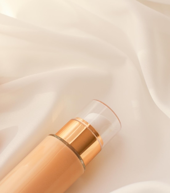 Tonal bb cream botella base de maquillaje fluido base para color de piel desnuda sobre fondo de seda producto cosmético como diseño de vacaciones de marca de belleza de lujo