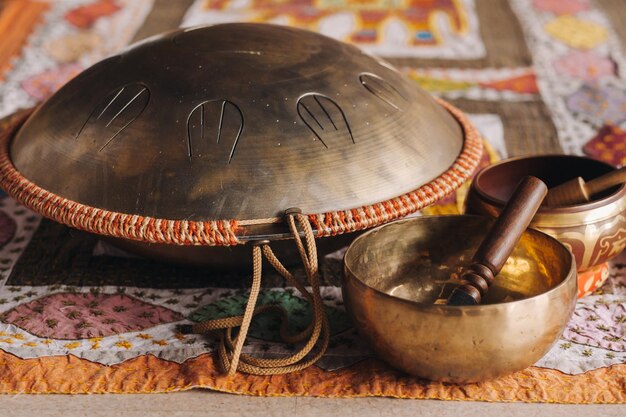 Tongue drum y cuencos tibetanos tirados en la alfombra