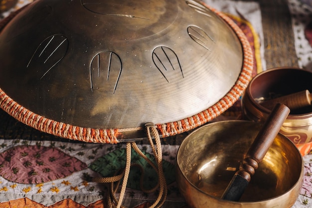 Tongue drum y cuencos tibetanos tirados en la alfombra