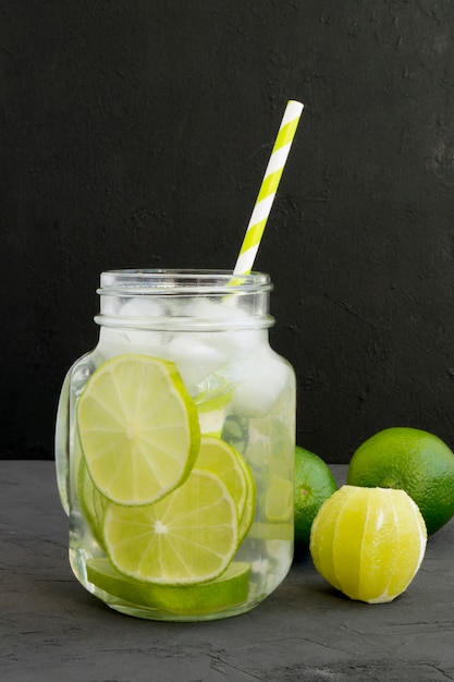 Tonificante limonada fresca con limón sobre un fondo gris.