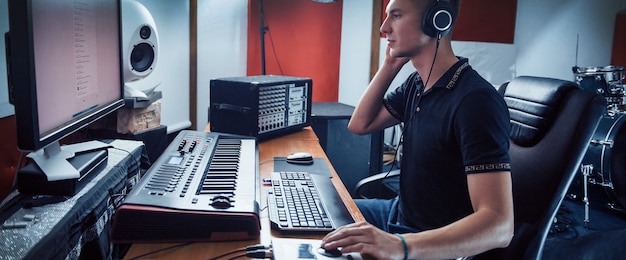 Foto toningenieur in kopfhörern, der im studio musik drinnen arbeitet und mischt.