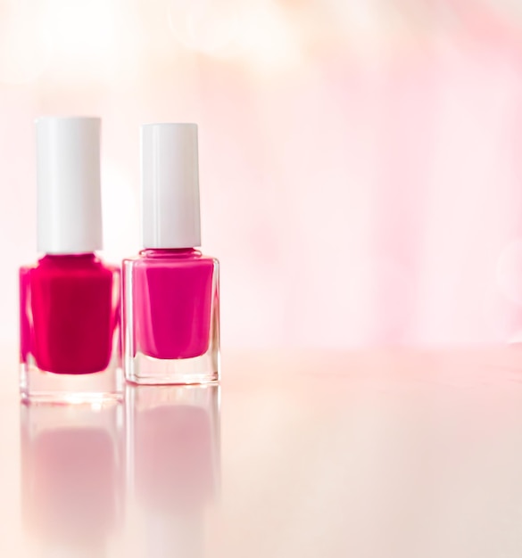 Tonos de esmalte de uñas rosa y rojo sobre fondo de glamour botellas de esmalte de uñas para manicura y pedicura marca de maquillaje y cosméticos de belleza de lujo