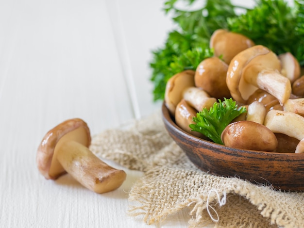 Tonschale mit Pilzen auf Sackleinen und einem separaten Pilz auf dem Tisch