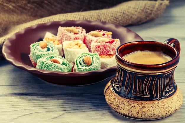 Tontasse Kaffee und Turkish Delight liegen auf Tonplatte auf Holzbrett