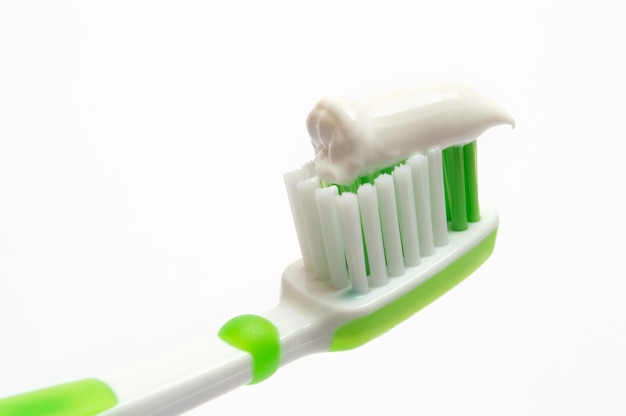 Toothbrush verde em um fundo branco