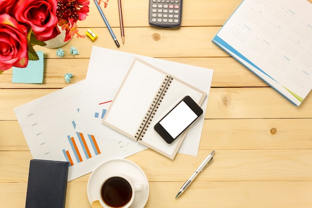 Top-Ansicht Business-Office die Charts und Grafiken auch Notebook, schwarzer Kaffee, Blume, stationär, Stift, Taschenrechner auf Büro Schreibtisch Hintergrund.
