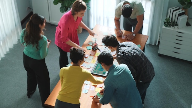 Foto top-ansicht des managers, der eine idee auf klebnoten schreibt und ein ideen-symposium erläutert