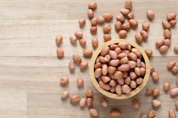 Top-Ansicht von Erdnüssen in einer Schüssel auf Holz-Hintergrund Gesundes Essen Konzept