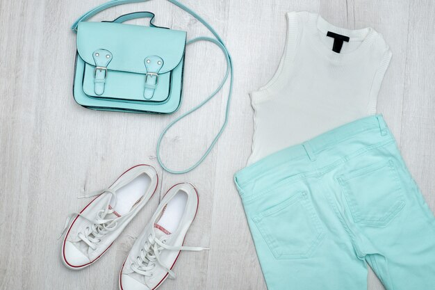 Top blanco, jeans color menta, zapatillas blancas y bolso. De moda De madera.