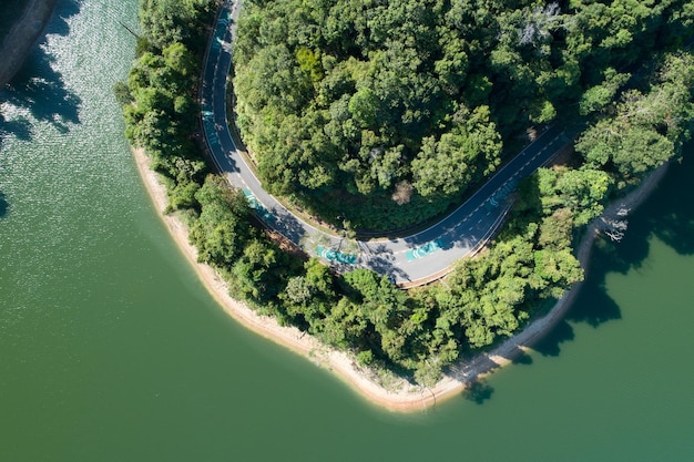 Top down von Drohne Luftbild des Regenwaldes mit Asphaltstraße um den Damm