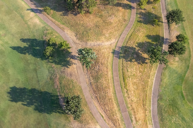 Top-Luftaufnahme der Naturlandschaft grüne Wiesen und Straßen auf dem Land an sonnigen Tagen