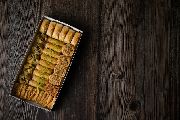 Top Of View Türkisches Baklava süßes Gebäck mit Box isolierten hölzernen Hintergrund