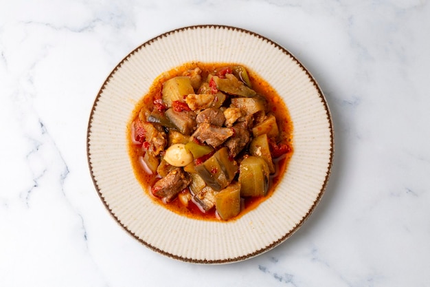 Top-View des türkischen Gerichtes Guvech gebackenes Fleisch mit Aubergine und traditionell in einem Lehmtopf serviert türkischer Name etli patlican guvec oder patlican tava