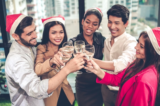 Top-View-Gruppe von Büroangestellten, die Weihnachten und Neujahr mit Klirrgläsern feiern und Wein zusammen mit glücklichem Lächeln und Lächeln im Büro trinken. Konzept der Feier der Firmenfeier.