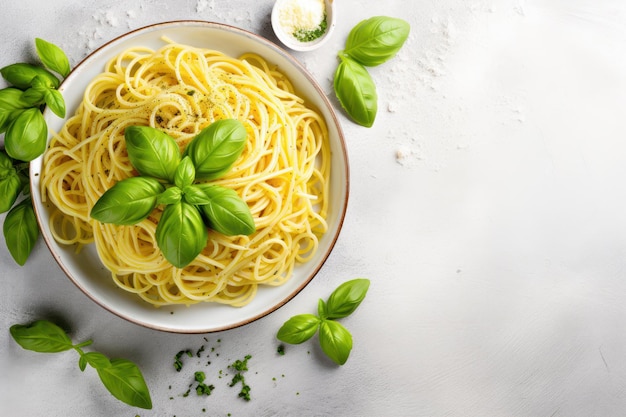 Top-View von Pasta-Spaghetti in einer grauen Schüssel mit Pesto-Sauce und frischen Basilikumblättern auf einem hellgrauen B