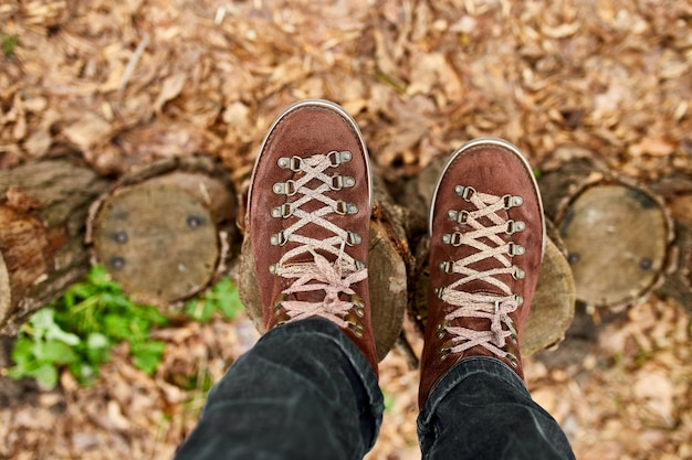 Top Viewoman stehend mit Wanderbergschuhen auf Herbstlaub und Holzhintergrund