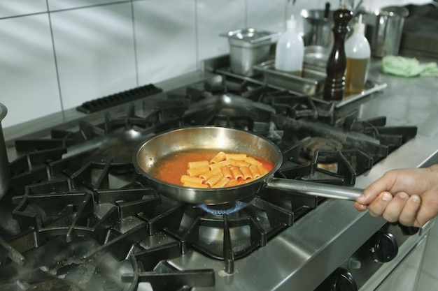 Foto topf mit nudeln auf dem feuerherd kochen