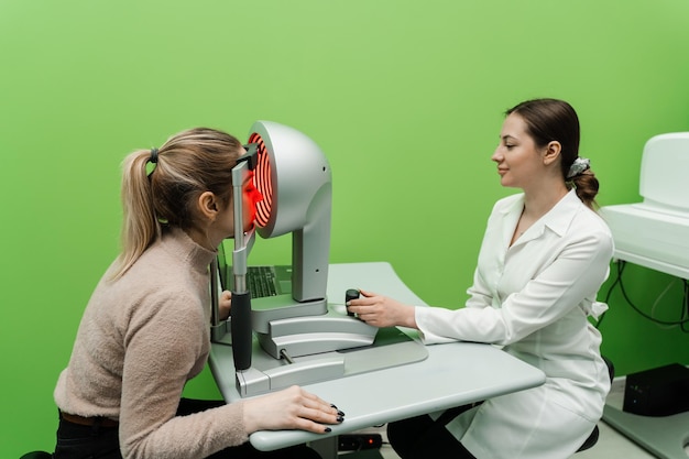 Topografía corneal prueba de visión ocular para la descripción visual de la forma y el poder de la córnea La luz roja del topógrafo corneal brilla sobre la mujer en el examen topográfico