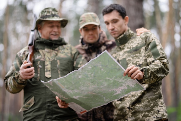 Topographische Karte in Händen der Jäger im Wald.