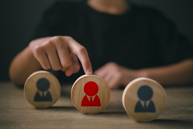 Foto toque com a mão um ícone humano em madeira escolha do líder de funcionários da multidão gestão de recursos humanos recrutamento de recursos humanos liderança e construção de equipe