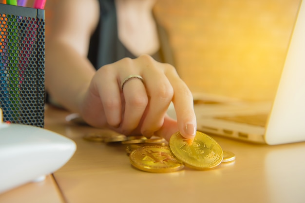 Foto toque de mulher de negócios e procurando bitcoin na mão com a beber café no escritório