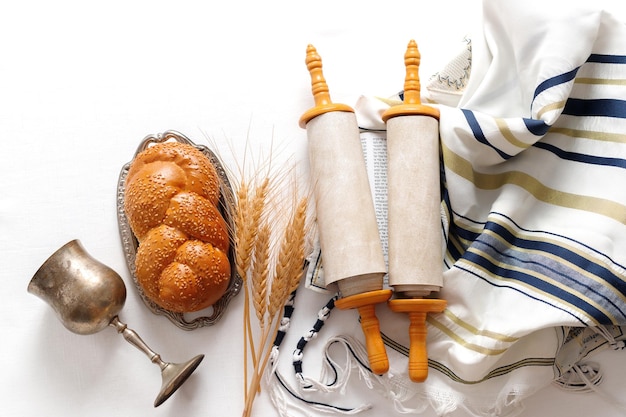 Tora-Schriftrolle Gebetsschal Tallit Kippa und Brot Konzept der jüdischen Feiertage Schawuot