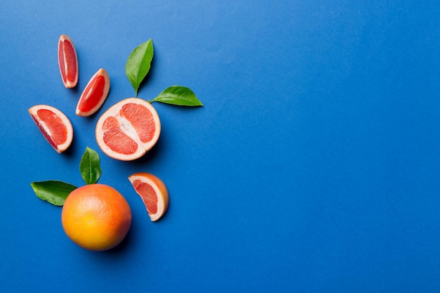 Toranja de frutas frescas com fatias de toranja suculentas em fundo colorido Vista superior Conceito criativo de verão do espaço de cópia Metade das frutas cítricas em postura plana mínima com espaço de cópia