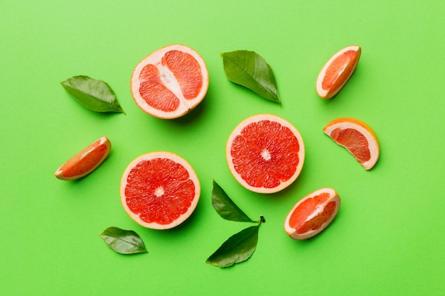 Toranja de frutas frescas com fatias de toranja suculentas em fundo colorido Vista superior Conceito criativo de verão do espaço de cópia Metade das frutas cítricas em postura plana mínima com espaço de cópia