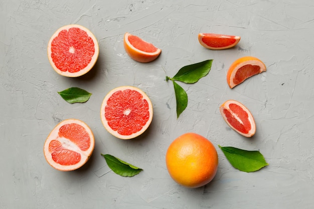 Toranja de frutas frescas com fatias de toranja suculentas em fundo colorido Vista superior Conceito criativo de verão do espaço de cópia Metade das frutas cítricas em postura plana mínima com espaço de cópia