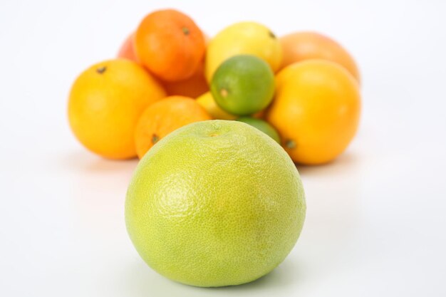 Toranja no fundo de diferentes frutas cítricas no fundo branco