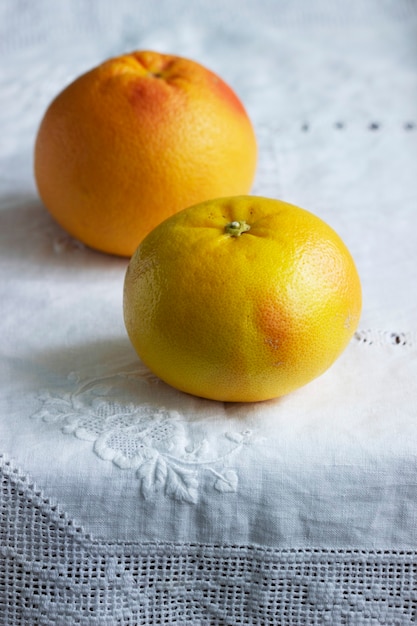 Toranjas maduras em uma toalha de mesa branca aparafusada. Foco seletivo.