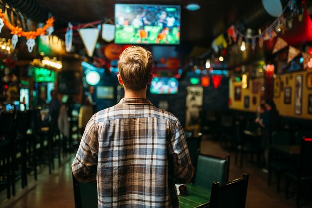 Torcedor de futebol assistindo a partida no sports bar