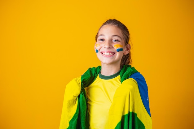 Torcedor de futebol, seleção brasileira. Linda garotinha torcendo por seu time em fundo amarelo