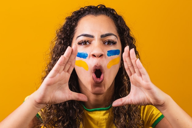 Torcida brasileira com o rosto pintado de azul e amarelo para o jogo do brasil. brasileiro comemorando a independência do brasil. 07 de setembro. torcida brasileira gritando de felicidade