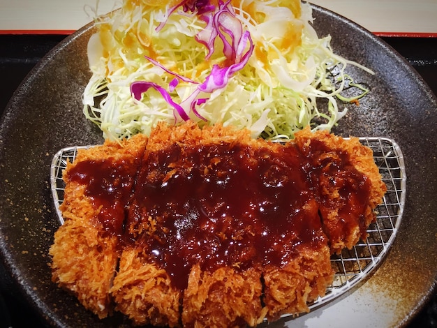 Torikatsu con verduras cocinadas en una sartén en la cocina