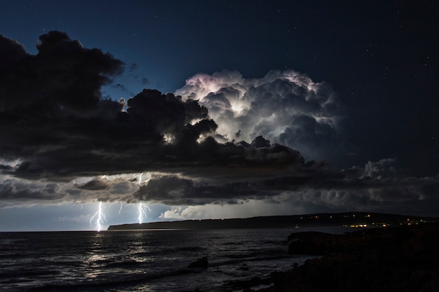 Tormenta eléctrica sobre el mar Mediterráneo con dos rayos cayendo al agua