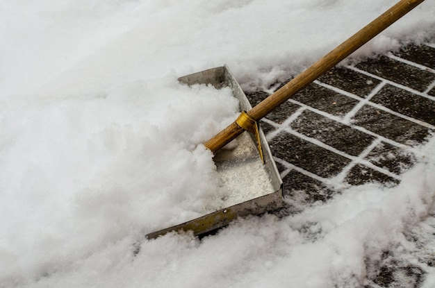 Tormenta de nieve en la ciudad Carreteras y aceras cubiertas de nieve Una pala grande para quitar el primer plano de la nieve Mal clima invernal Limpieza de calles después de la tormenta de nieve