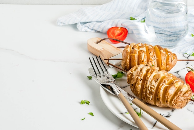 Tornado-käsige Kartoffeln mit Petersilie und Tomaten, auf weißem Marmorhintergrund, Kopienraum