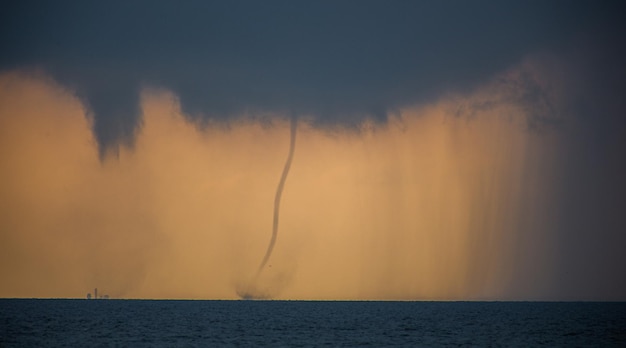 Tornado no mar durante o dia contra o céu